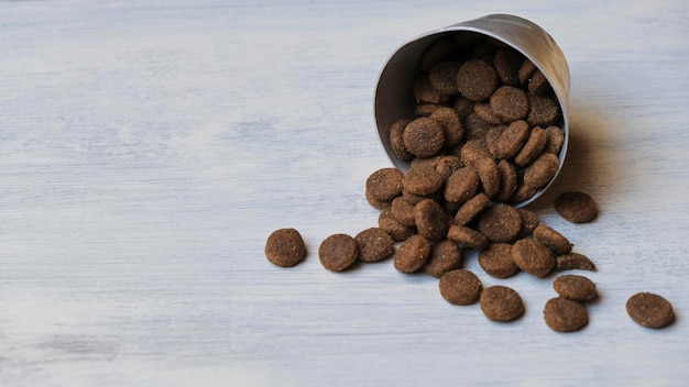 Bol de biscuits pour chiens jetés sur un fond de bois clair