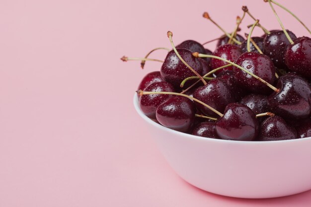 Bol blanc de cerises rouges fraîches.