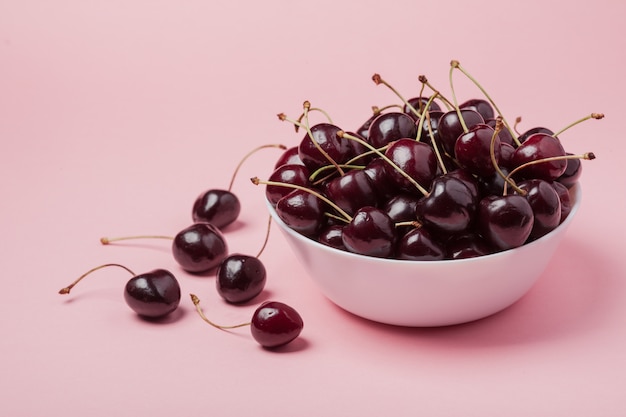 Bol blanc de cerises rouges fraîches.