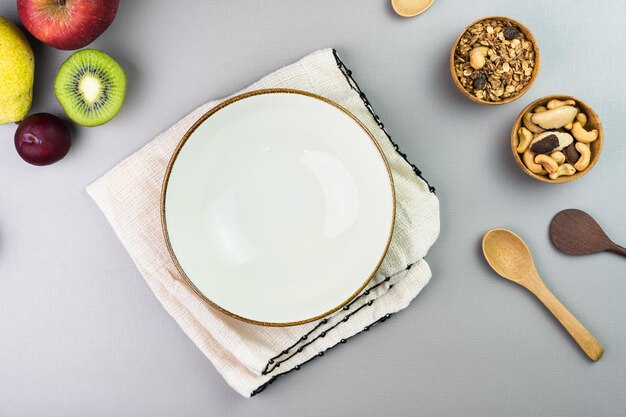 Un bol blanc avec des fruits frais sur le côté Fruits multicolores et tropicaux Supplémentaire avec châtaignes et granola Vue de dessus Mise au point sélective