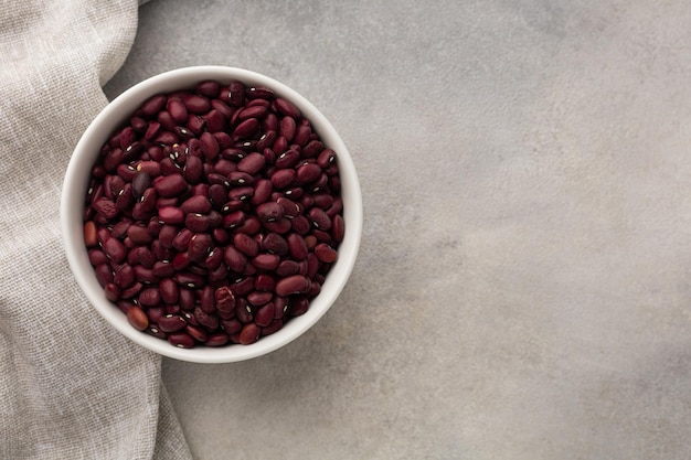 Bol blanc avec des haricots secs rouges sur fond clair