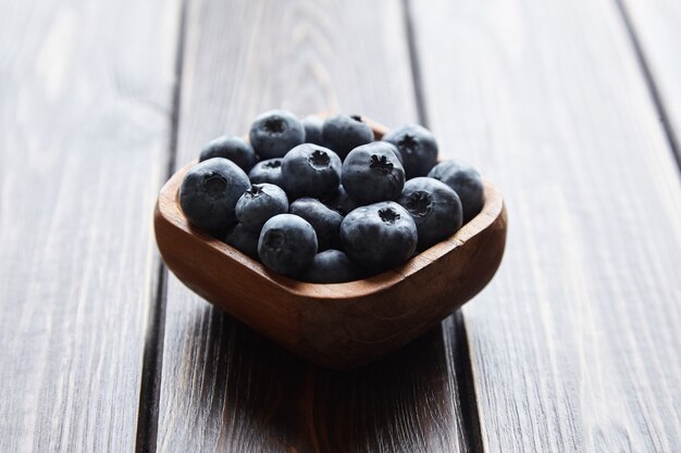 Bol avec des bleuets frais sur une table en bois