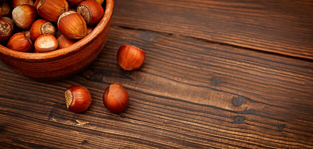 Bol en bois aux noisettes sur une table en bois noir