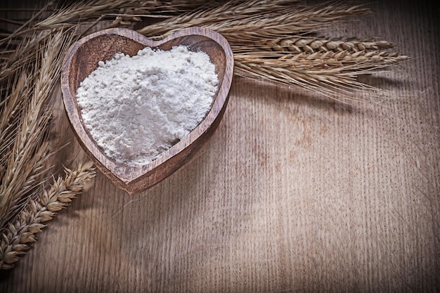 Bol en bois avec bouquet de farine d'épis de blé de seigle sur planche de bois concept de nourriture et de boisson