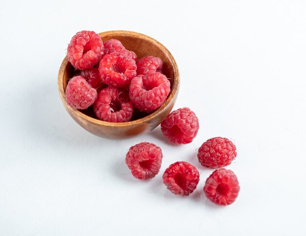 bol en bois de délicieuses framboises saines sur table en pierre