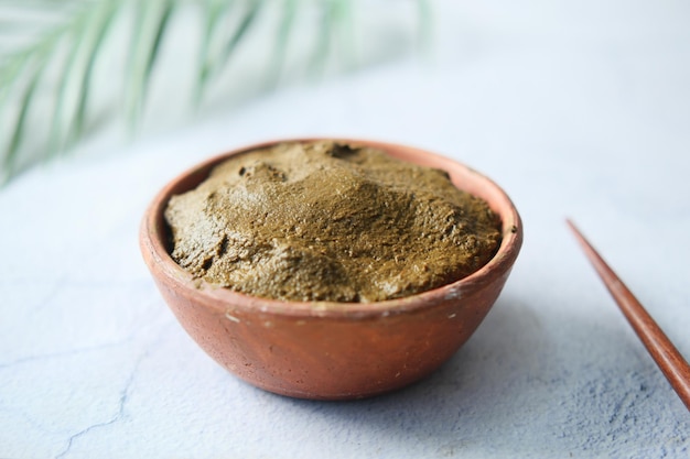 Le bol en bois avec du henné réhydraté sur table