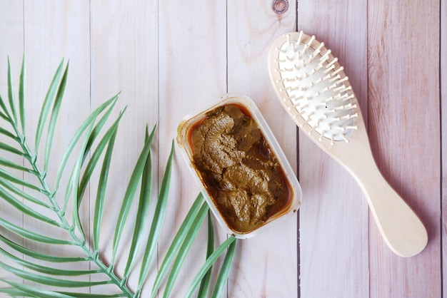 Photo le bol en bois avec du henné réhydraté sur table