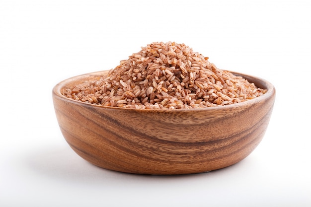 Bol en bois avec du riz brun non poli isolé sur fond blanc