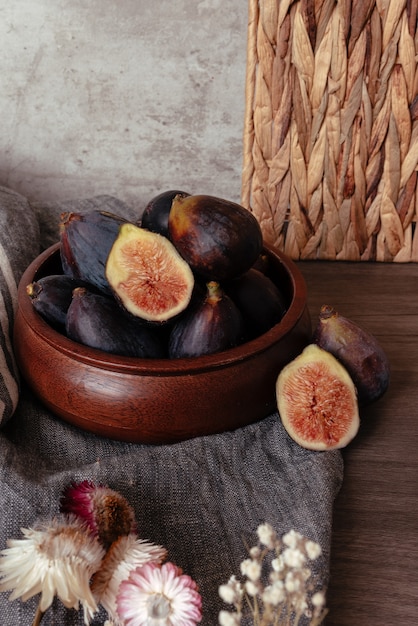 Photo bol en bois avec des figues entières et coupées en deux