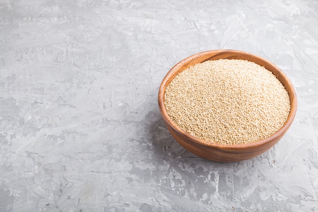 Bol en bois avec des graines de quinoa blanc cru