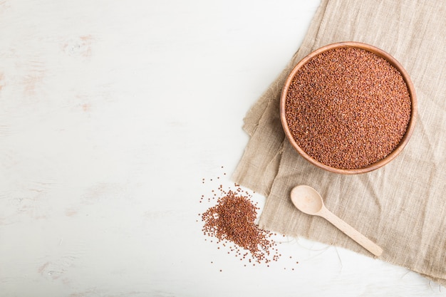 Bol en bois avec des graines de quinoa rouge cru