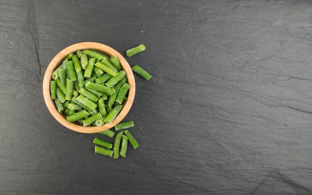 Bol en bois avec haricots verts surgelés Vue de dessus