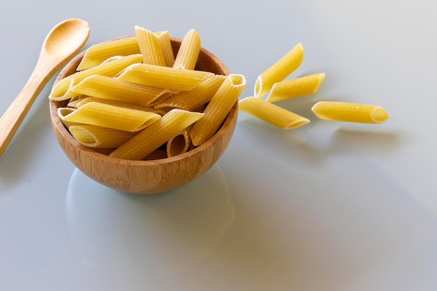 Bol en bois avec pâtes pene crues