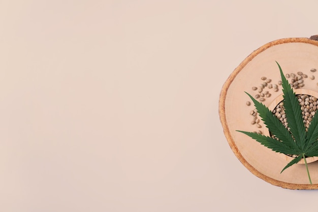 Bol en bois sur une plaque en bois pleine de graines de chanvre Concept de cannabis légalisé