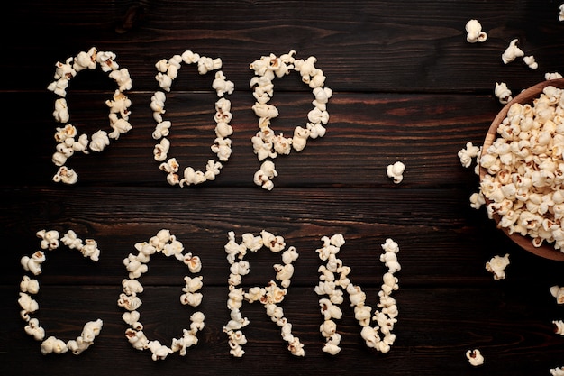 Bol en bois avec pop-corn salé sur une table en bois