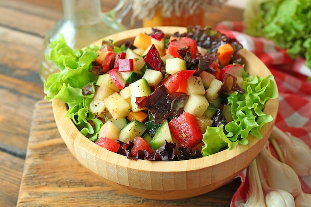 Bol en bois de salade de légumes frais sur table libre