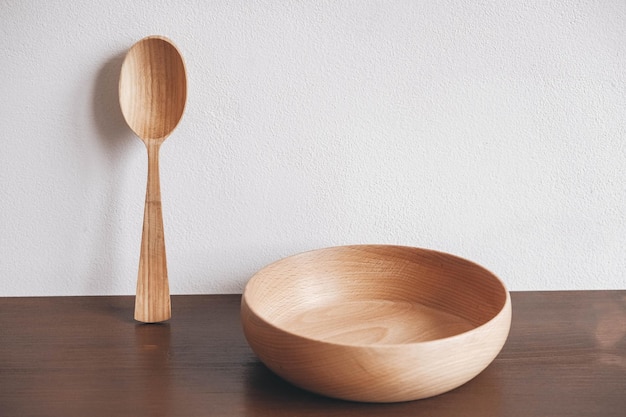 Bol en bois vide et cuillère en bois sur un fond de table marron. Copie, espace vide pour le texte