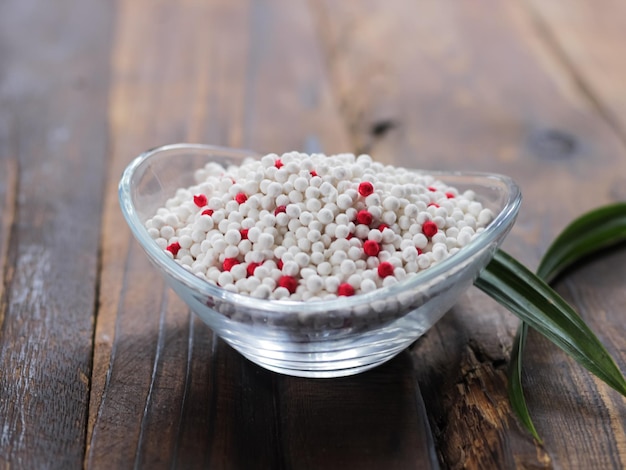 Un bol de bonbons blancs et rouges sur une table en bois