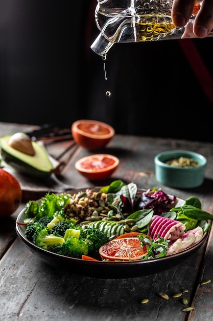 Bol de bouddha végétarien végétal avocat orange sanguine brocoli pastèque radis épinards quinoa graines de citrouille image verticale place pour le texte