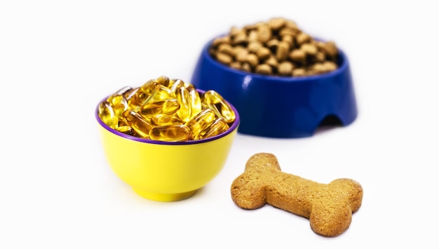 Photo bol de capsules d'oméga 3 avec bol de nourriture pour chien et cookie à côté de l'espace de copie de nourriture pour chiot maison