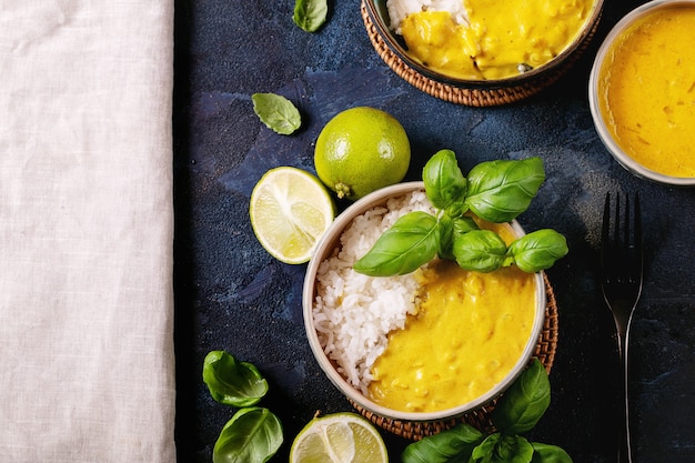 Bol en céramique de curry jaune servi avec basilic et limes