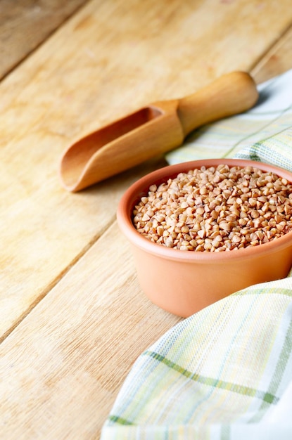 Bol en céramique de grains de sarrasin biologiques rôtis sur table de cuisine