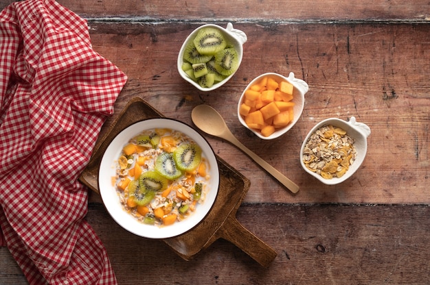 Bol de céréales avec du lait et des fruits sur fond de bois délicieux petit déjeuner sain vue de dessus