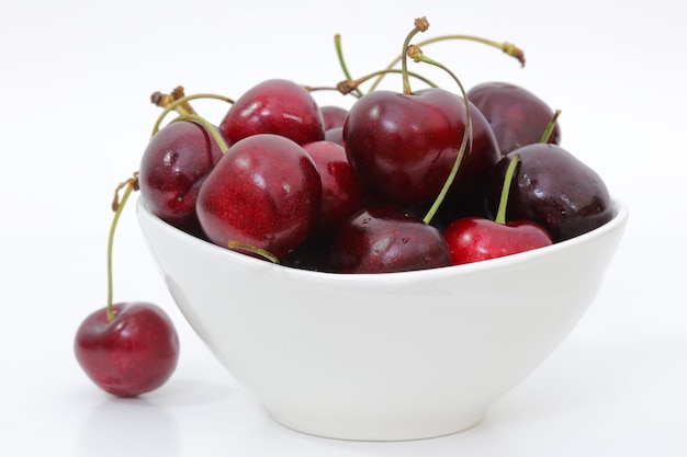 Un bol de cerises sur fond blanc