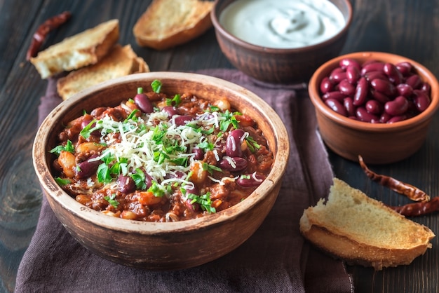 Bol de chili con carne avec des toasts et de la crème sure