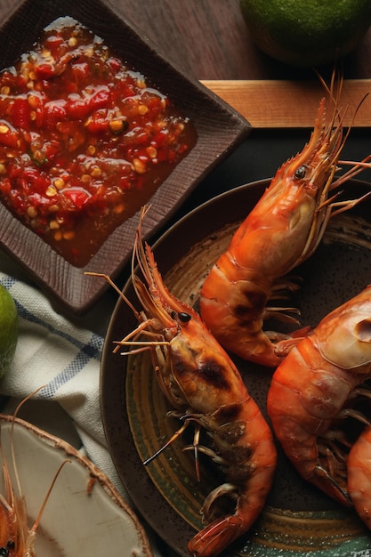 Un bol de crevettes avec un bol de salsa sur le côté