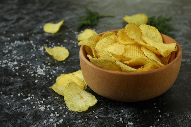 Bol avec des croustilles sur une surface fumée noire