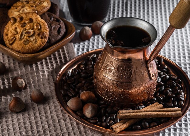 Bol en cuivre vintage de café chaud, boisson au café avec des biscuits et des noix vue de dessus