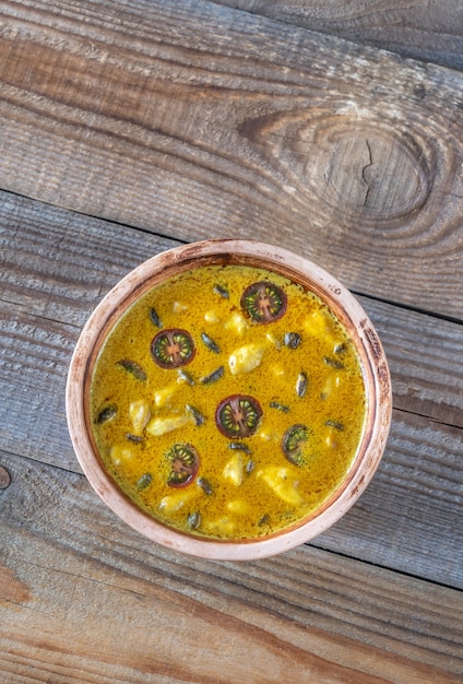 Bol de curry aux champignons jaunes sur la table en bois