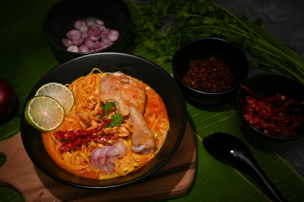 Un bol de curry de poulet du nord de la Thaïlande avec des nouilles aux œufs avec des légumes ou Khao Soi Kai