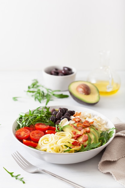 Bol déjeuner cétogène: courgette spiralée à l'avocat, tomate, fromage feta, olives, bacon