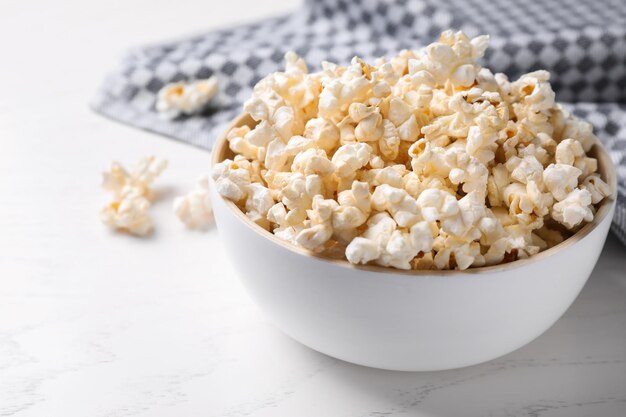 Bol de délicieux pop-corn sur table lumineuse