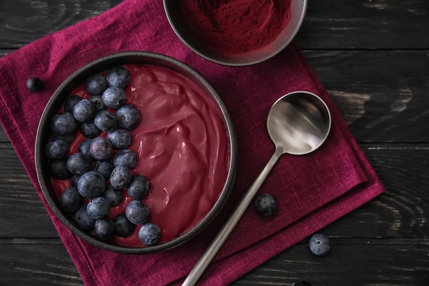 Bol avec un délicieux smoothie d'açai sur une table en bois