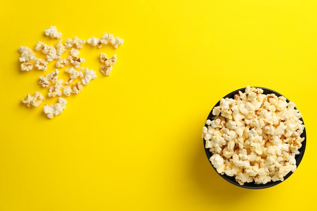 Bol avec du pop-corn savoureux sur jaune.