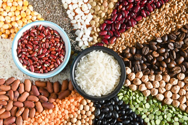 Bol avec du riz blanc cru et des haricots sur diverses graines de grain