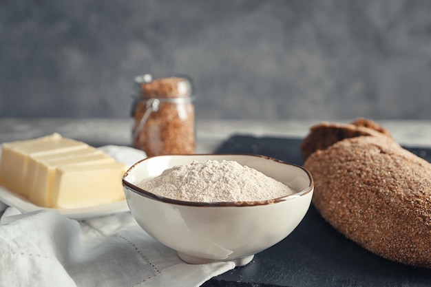 Bol avec farine de sarrasin et pain frais sur table