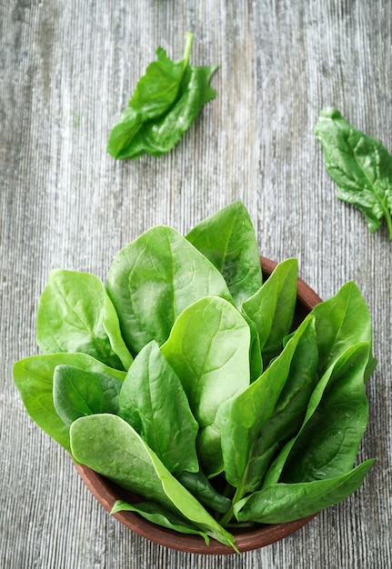 Bol avec des feuilles d'épinards frais sur la table