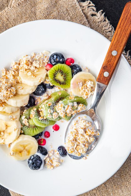 bol de flocons d'avoine petit déjeuner aux fruits lait végétal sans lactose banane kiwi baies myrtilles