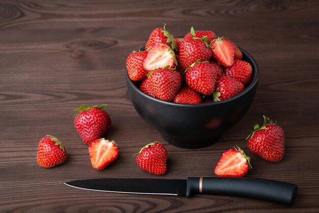 Bol de fraise et couteau noir sur table