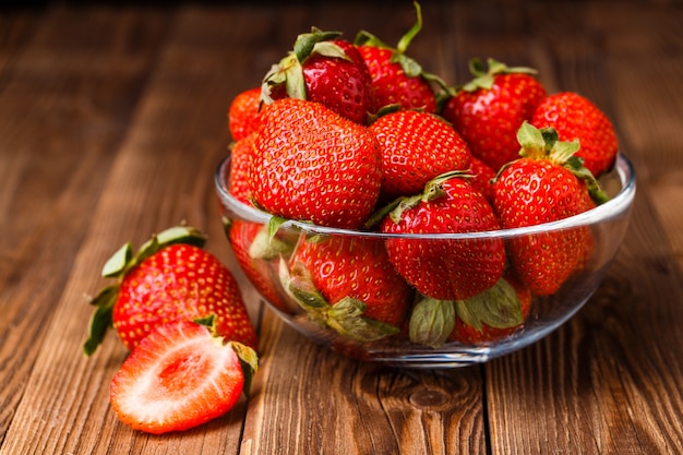 Bol avec des fraises fraîches sur table en bois