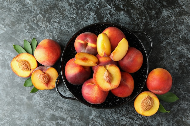 Bol avec des fruits de pêche sur une table smokey noire