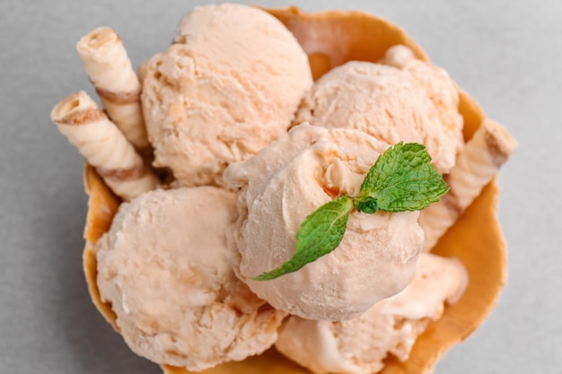 Bol à gaufres avec glace au caramel sur fond gris gros plan