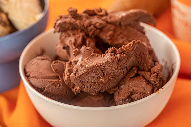 Un bol de glace au chocolat avec un bol de glace en arrière-plan.