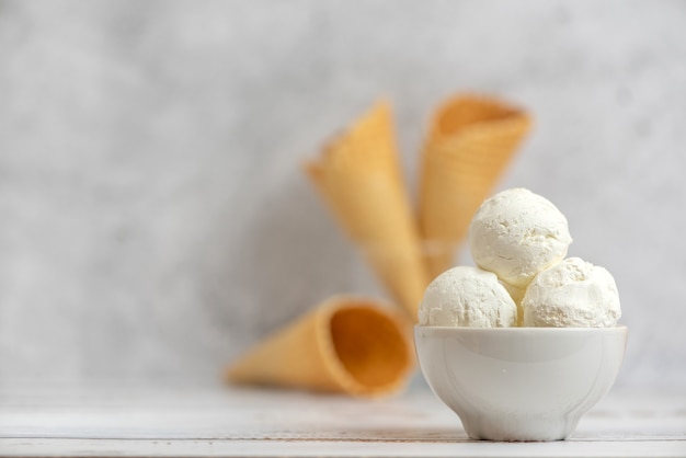 Bol de glace à la vanille et cornets gaufres à la lumière.