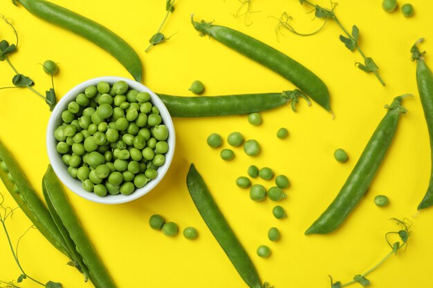 Bol avec des graines de pois frais sur jaune