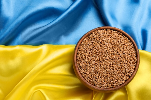 Bol de grains de blé sur la vue de dessus du drapeau ukrainien Espace pour le texte